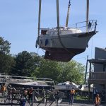Image of boat being hoisted by crane